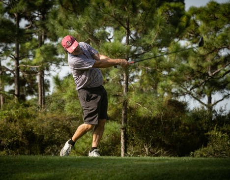 A person swinging a golf club

Description automatically generated